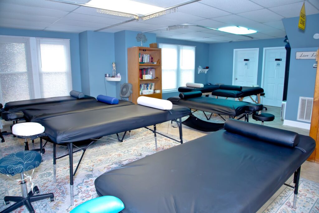 Massage tables with face cradles and stools set up for hands-on practice in the NC Massage School classroom
