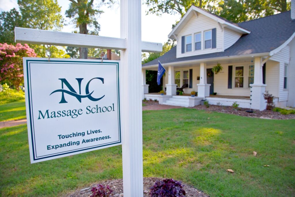 NC Massage School sign reading Touching Lives. Expanding Awareness. in front of the school on North Main Street in Cornelius